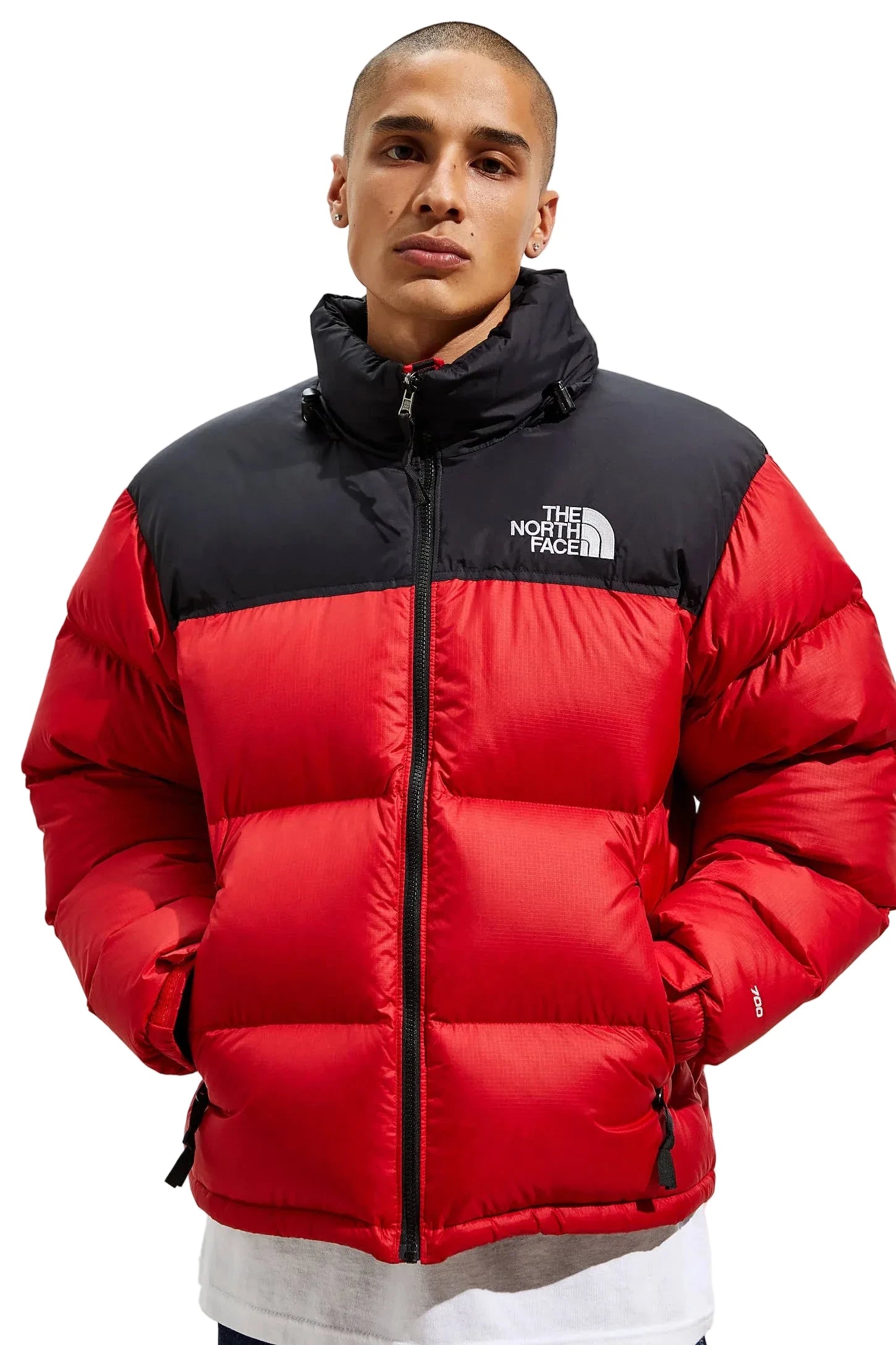 Person wearing a red and black puffer jacket with 'The North Face' logo on a white background