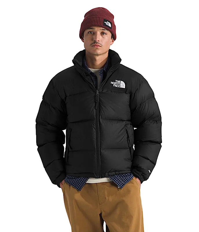 Person wearing a black puffer jacket with 'The North Face' logo on a white background